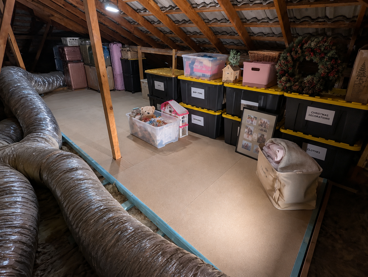 Attic storage platform filled with labelled boxes, suitcases and seasonal storage
