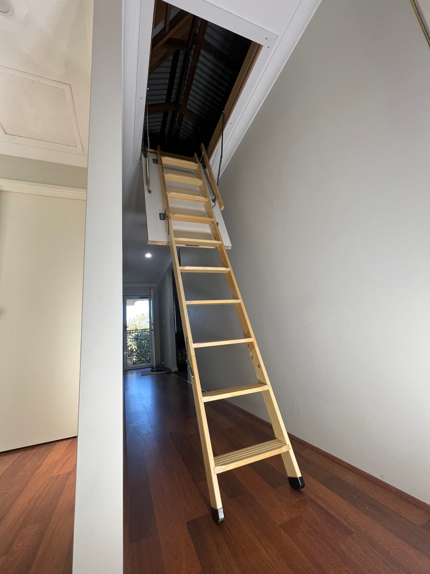 Timber attic ladder extended into a hallway